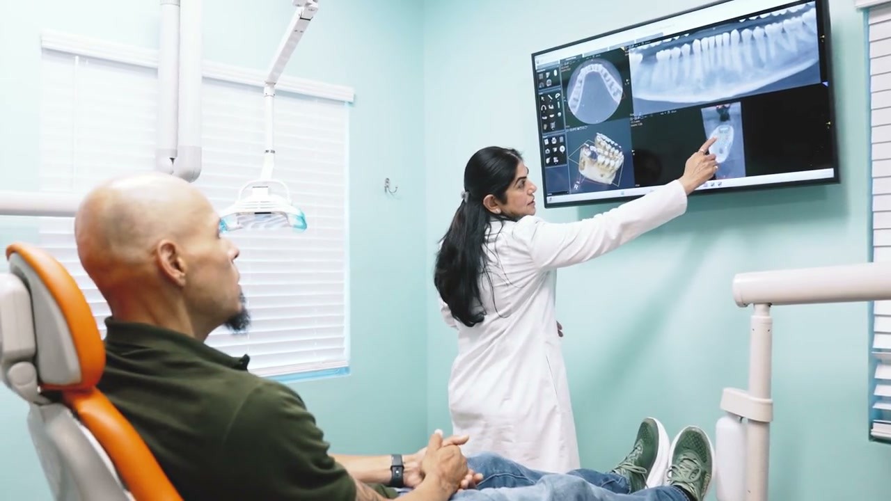 Dr. Uttma Dham reviewing a 3D CBCT scan on a monitor