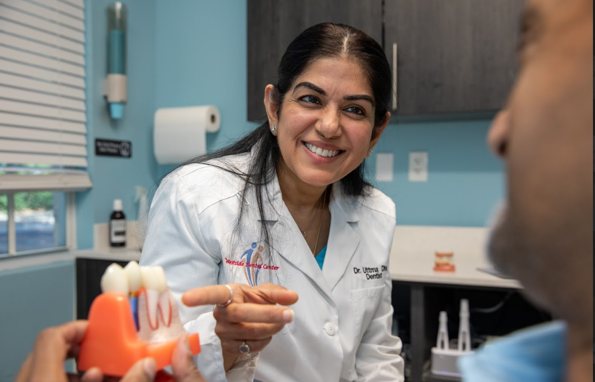 Dr. Dham explaining a dental crown with a model
