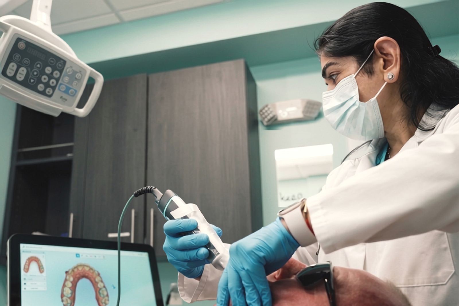 Dr. Uttma Dham taking a digital intraoral scan of a patient