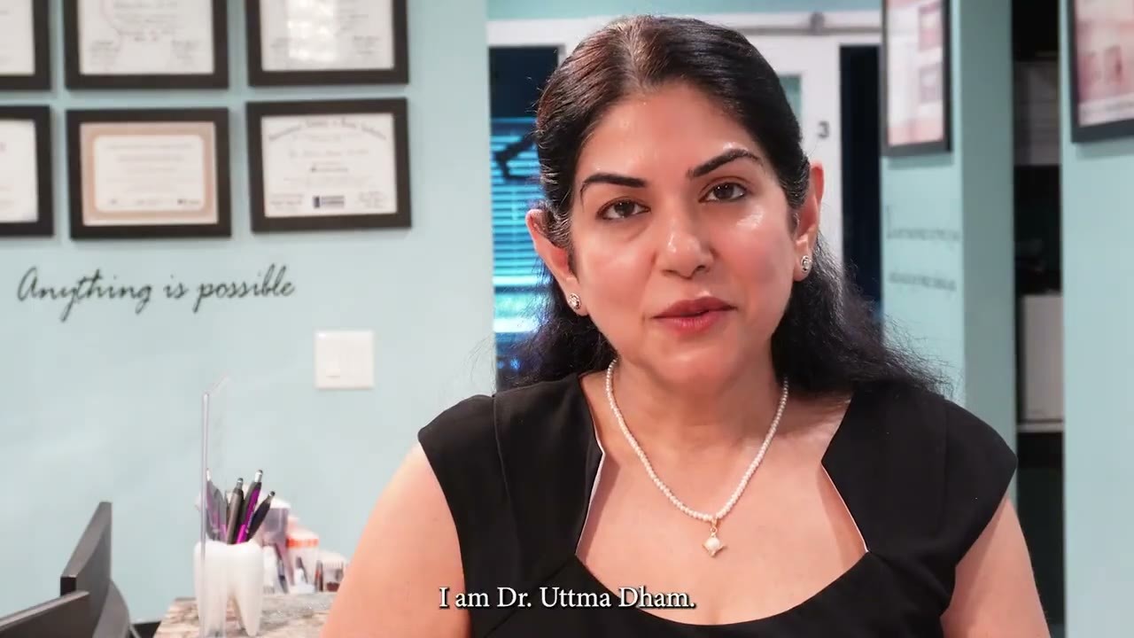Dr. Uttma Dham speaking to the camera in the Westside Dental Center office