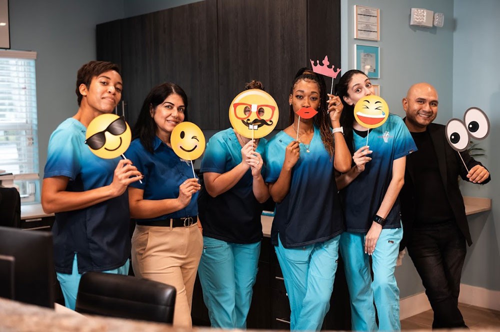 Westside Dental Center team posing with emoji photo props
