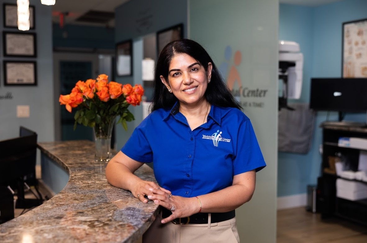 Dr. Uttma Dham at the Westside Dental Center reception desk