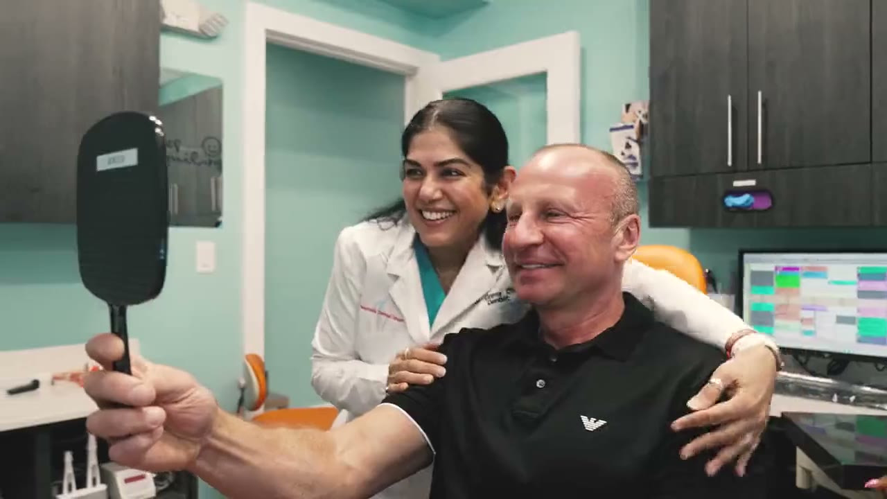 Dr. Uttma Dham with a smiling patient at Westside Dental Center